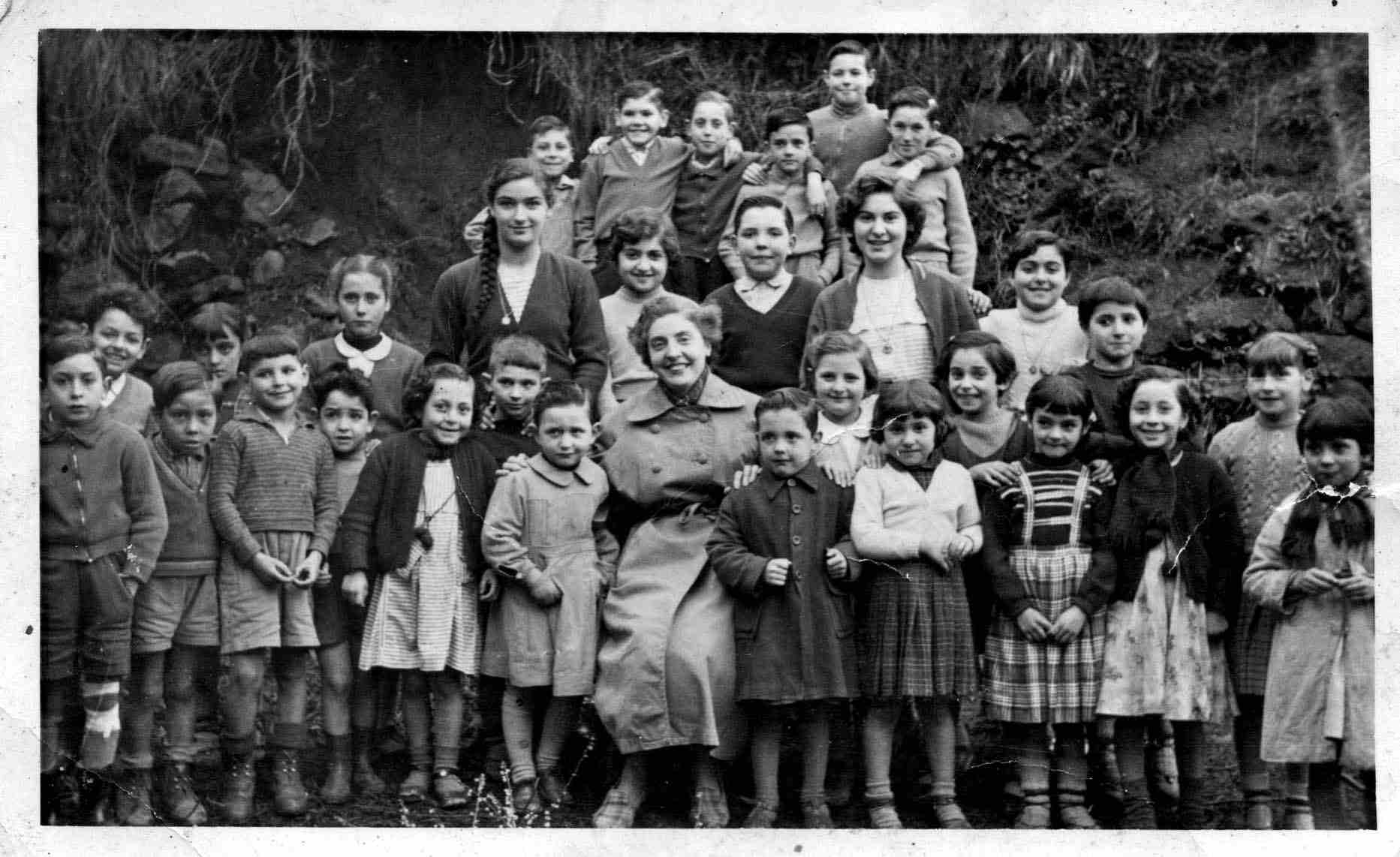 1956.57. Alumnos y profesora de la primera escuela unitaria (anexa al caserío situado al borde de la carretera.)